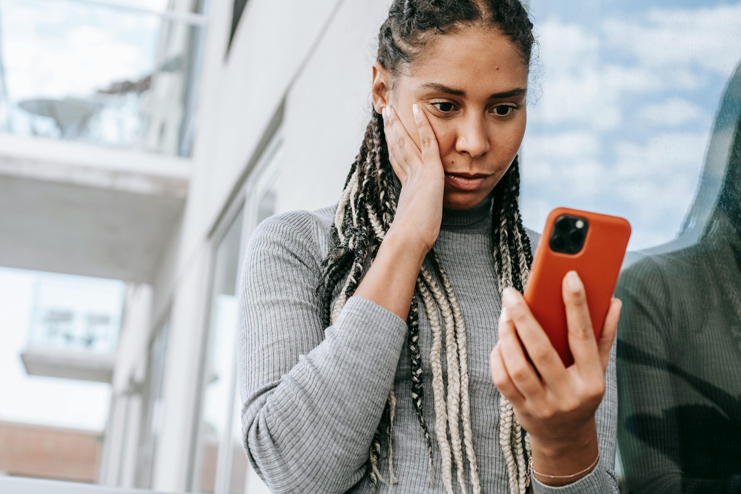 women looking at phone with a distressed face